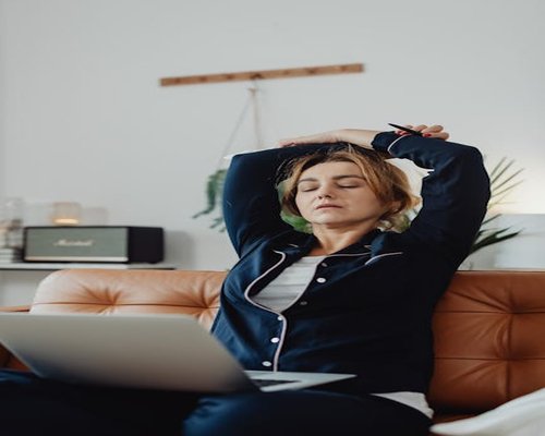 Person taking a break from laptop, stretching arms