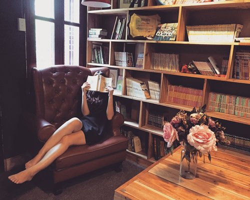 Person relaxing in an armchair reading a book