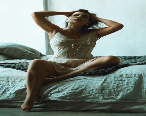 Person stretching gently in bed upon waking up