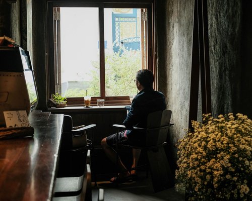 Person looking out the window taking a deep breath in the morning